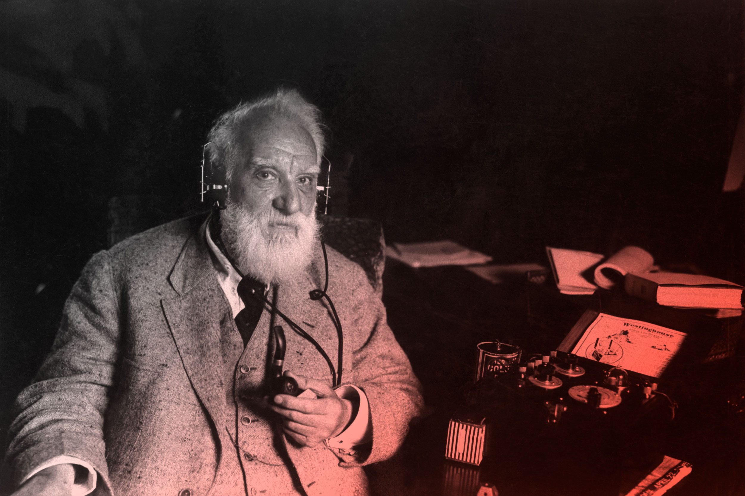 alexander graham bell sitting next to one of his inventions