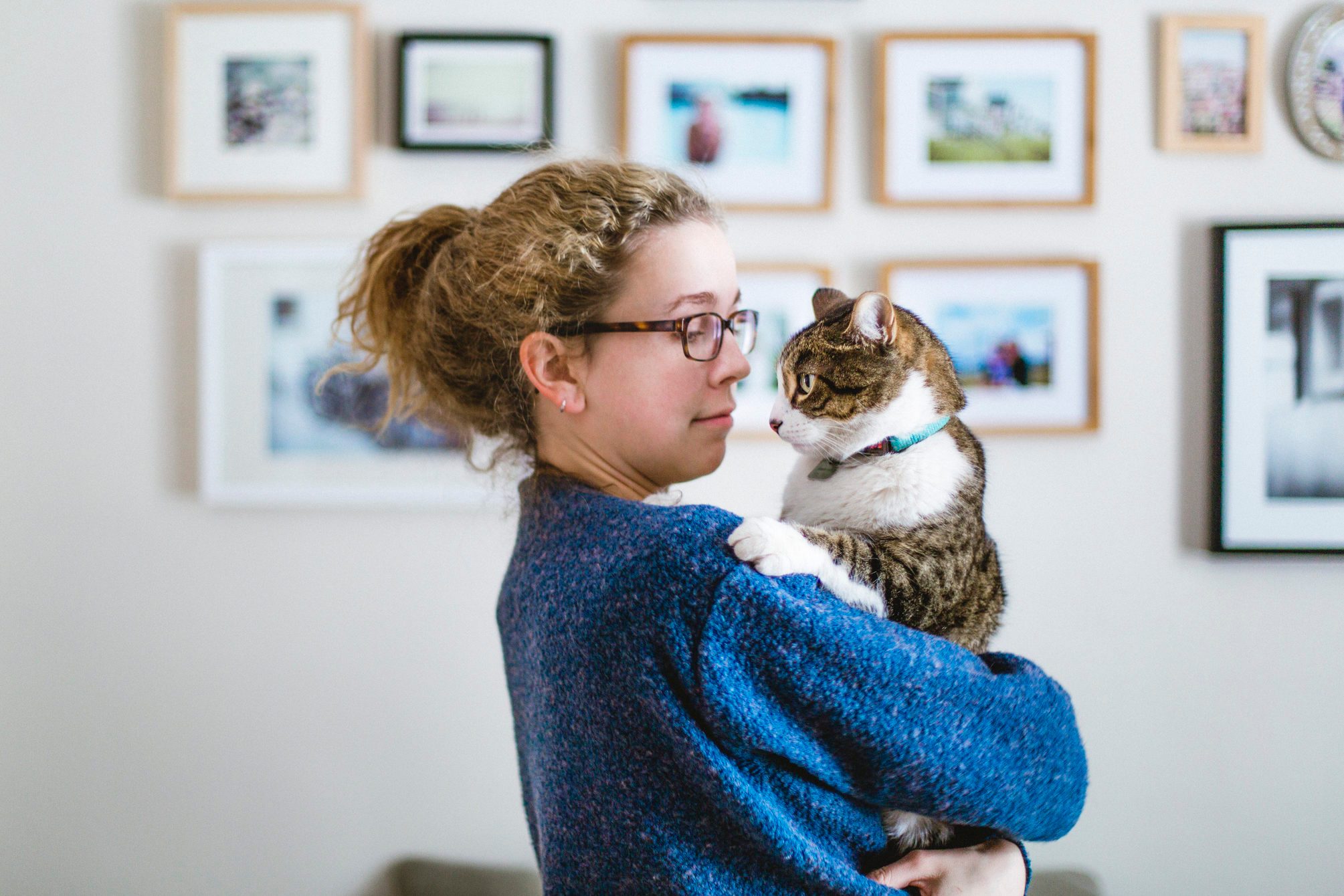 Face to face between a girl and her tabby cat