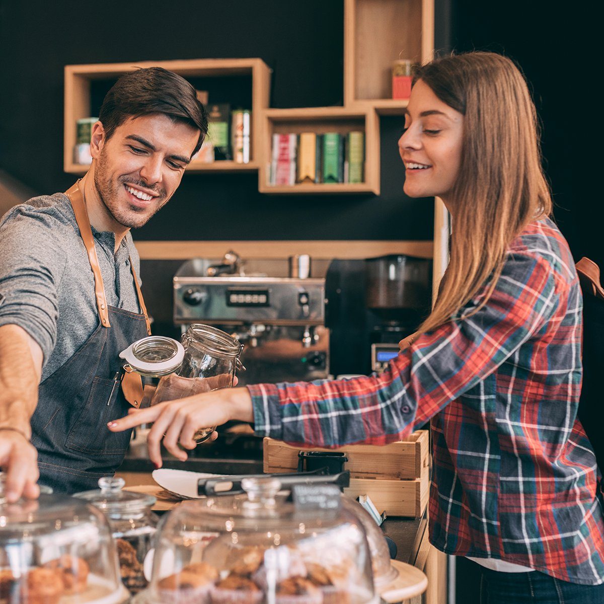 Woman showing a cashier which cookies she wants to purchase.