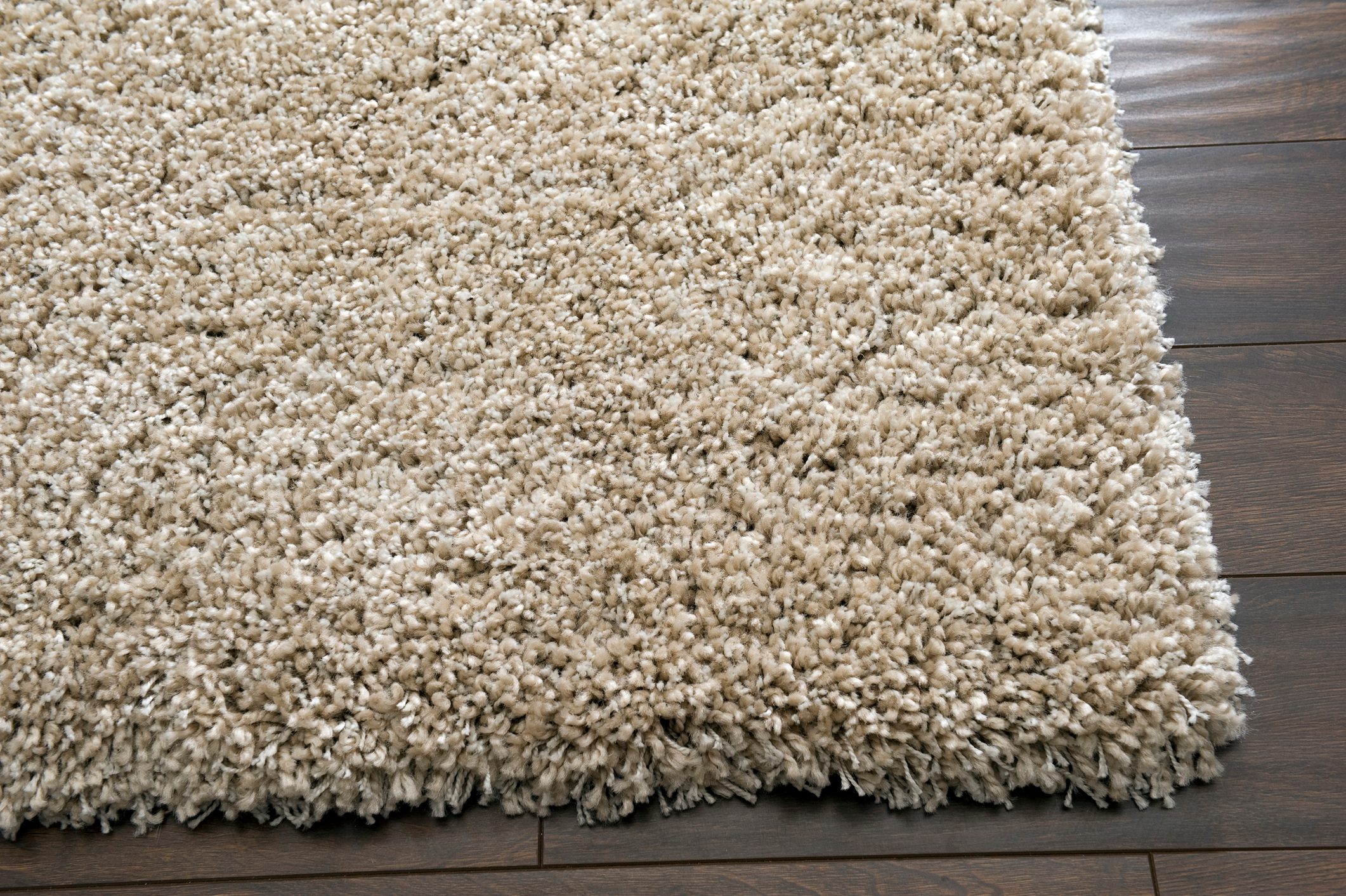 A cream rug on a dark wooden floor