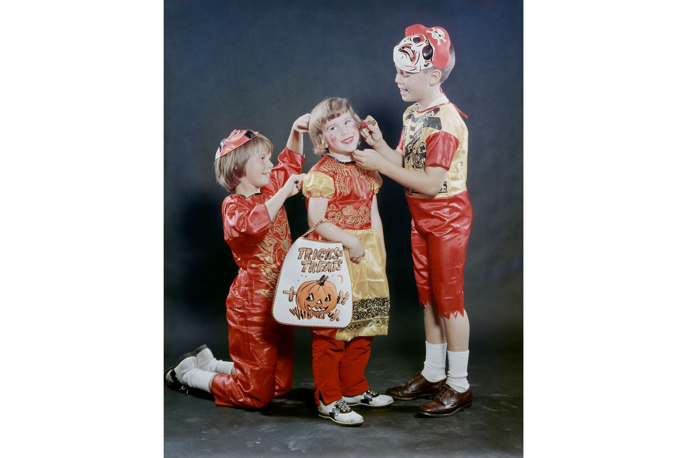 boys dressed as pirates help their sister get ready for halloween