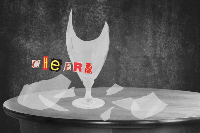 Shattered Glass On Wooden Table With Text Cheers