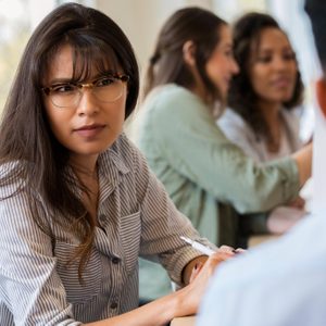 Young female creative professional listens to coworker