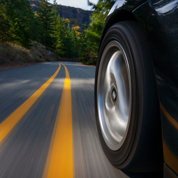 Black sports car motion country road.