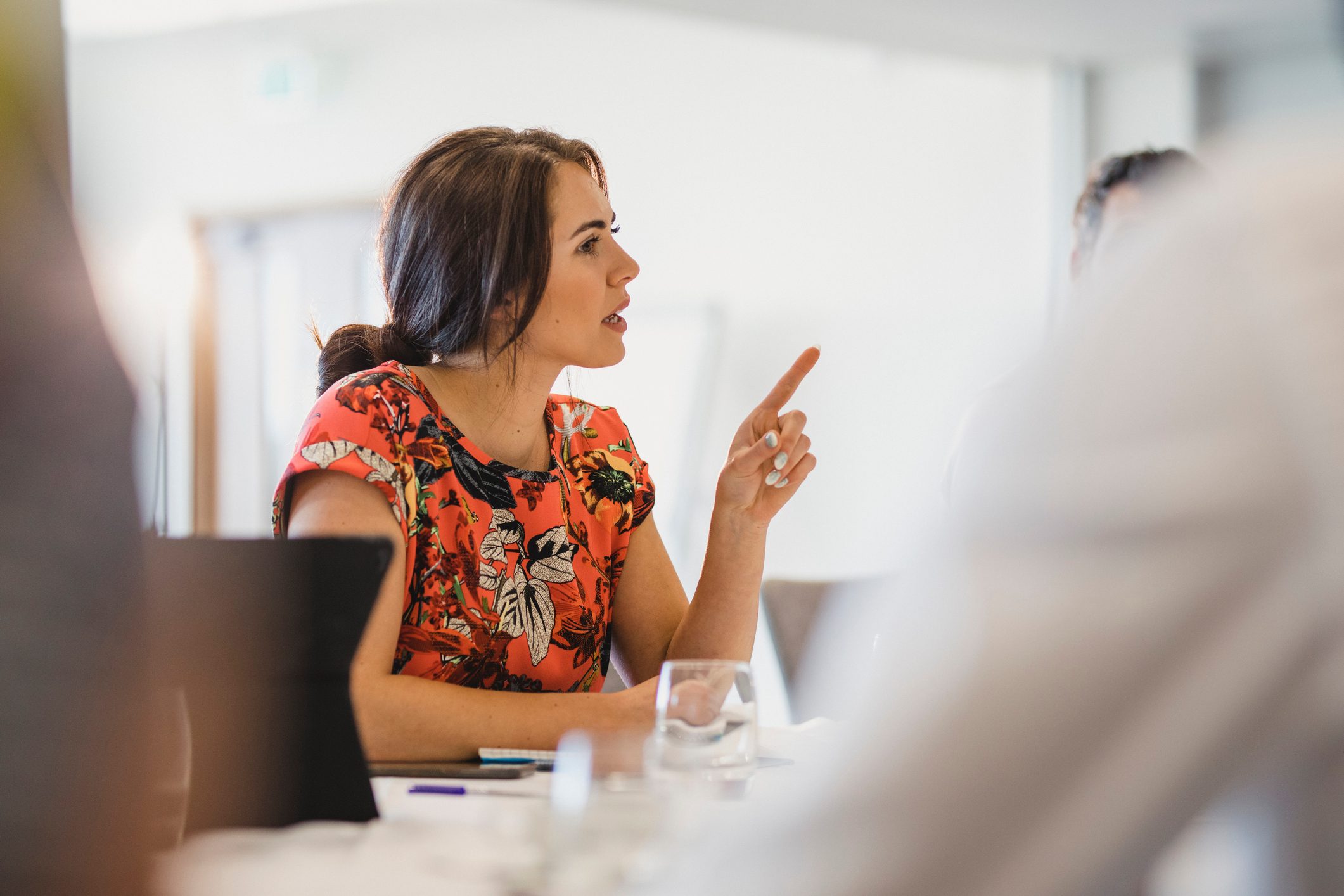 Confident young businesswoman explaining in work meeting