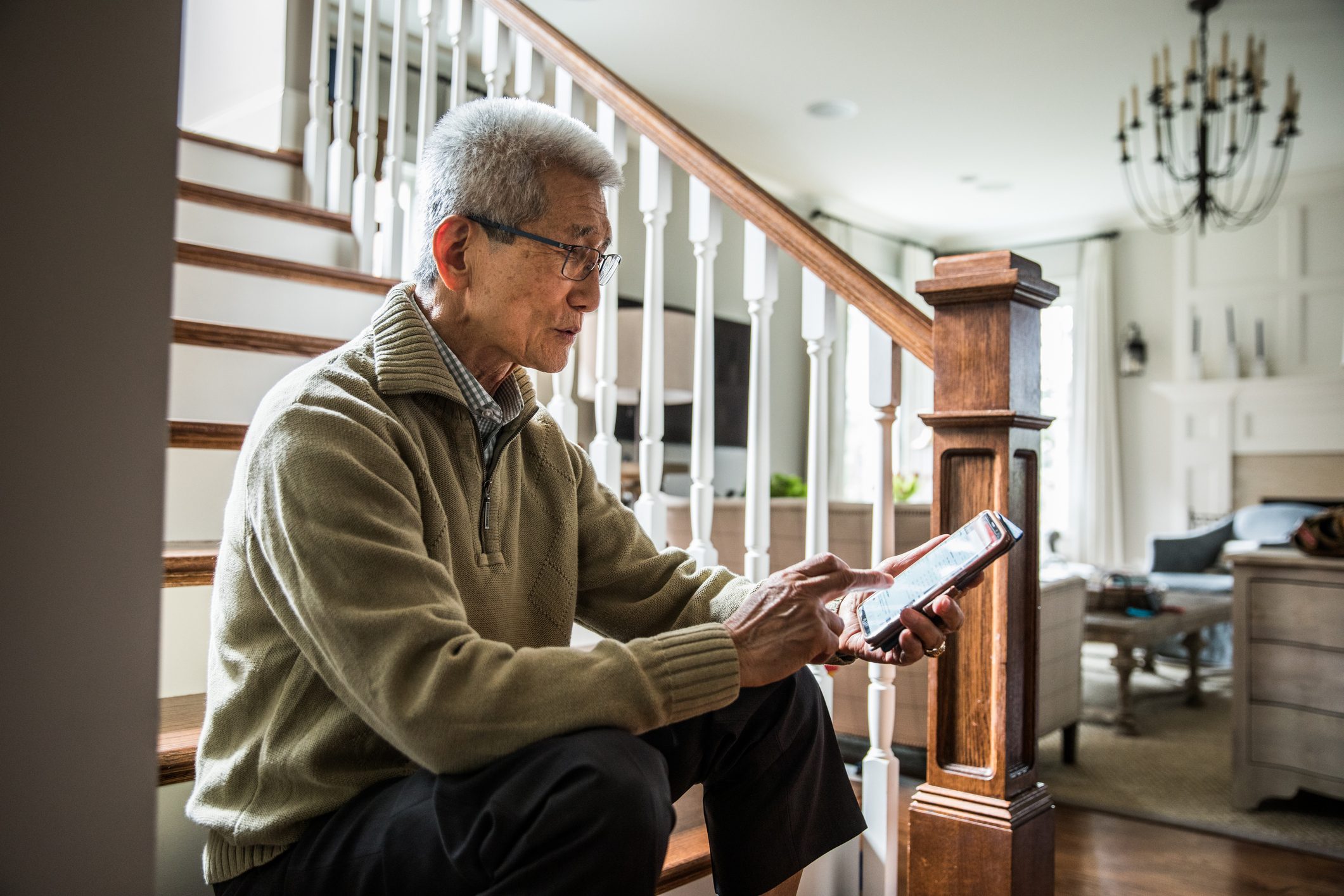 Senior man listening to music on laptop wearing headphones