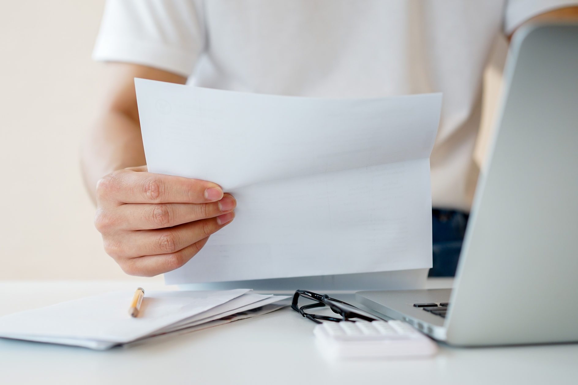 close up man hand holding invoice paper form mail to reading and check list of spending of the month and planing to manage money for financial and life concept