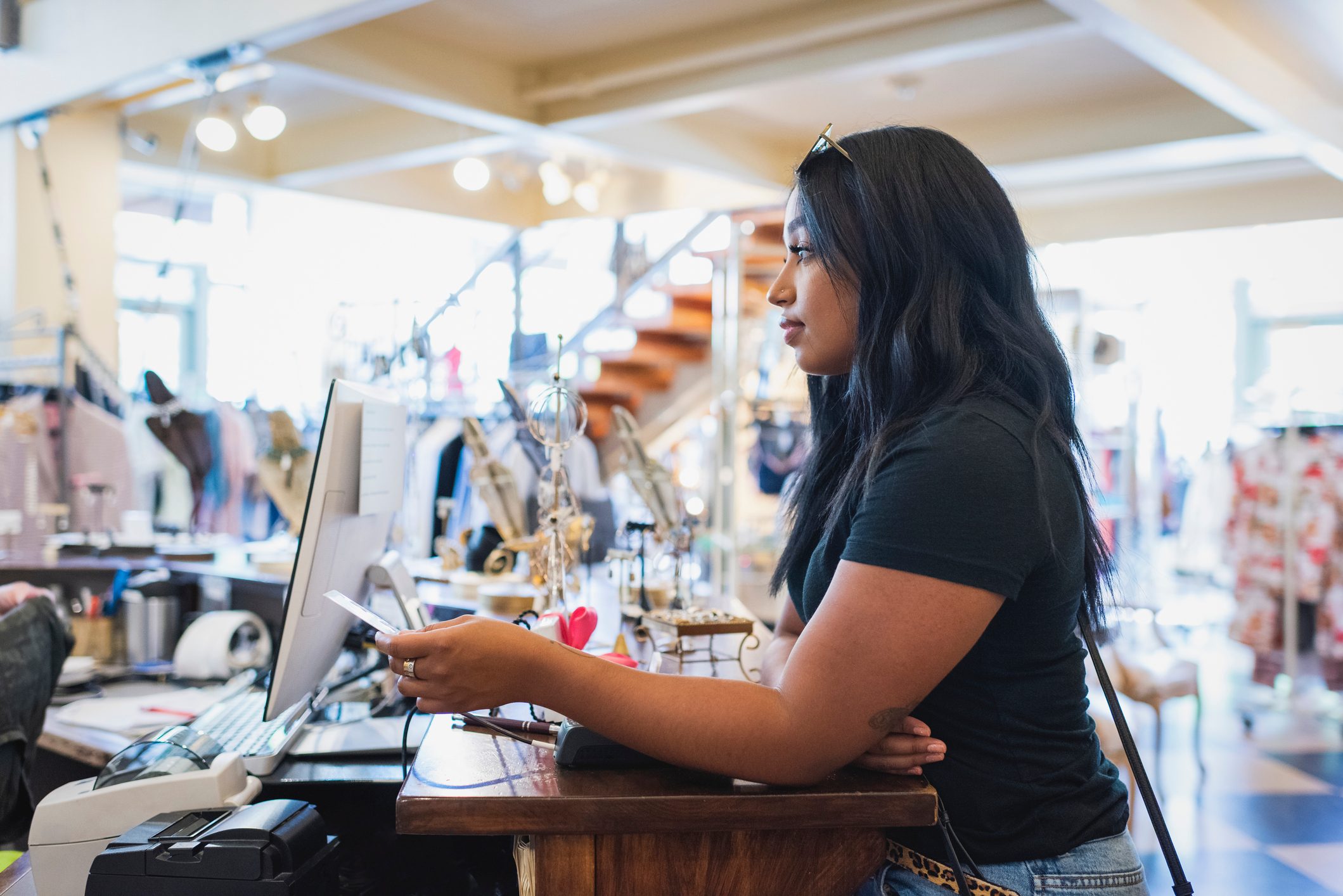 Young woman paying cashier in clothing store