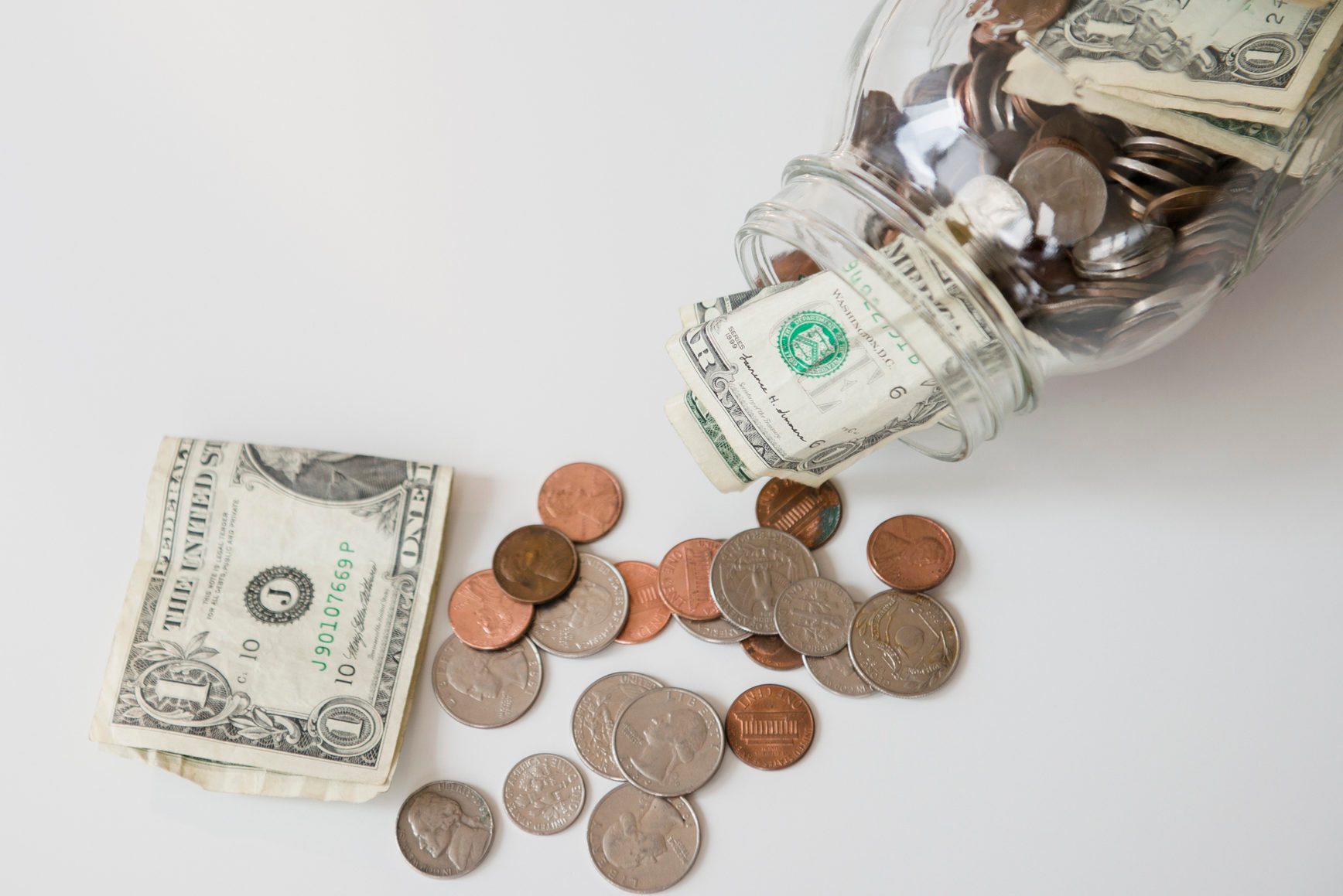 Studio shot of banknotes and coins in jar