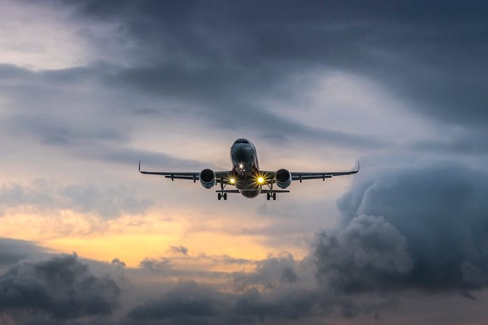 Airplane landing in dramatic sunset