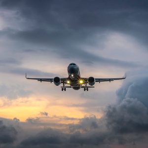 Airplane landing in dramatic sunset