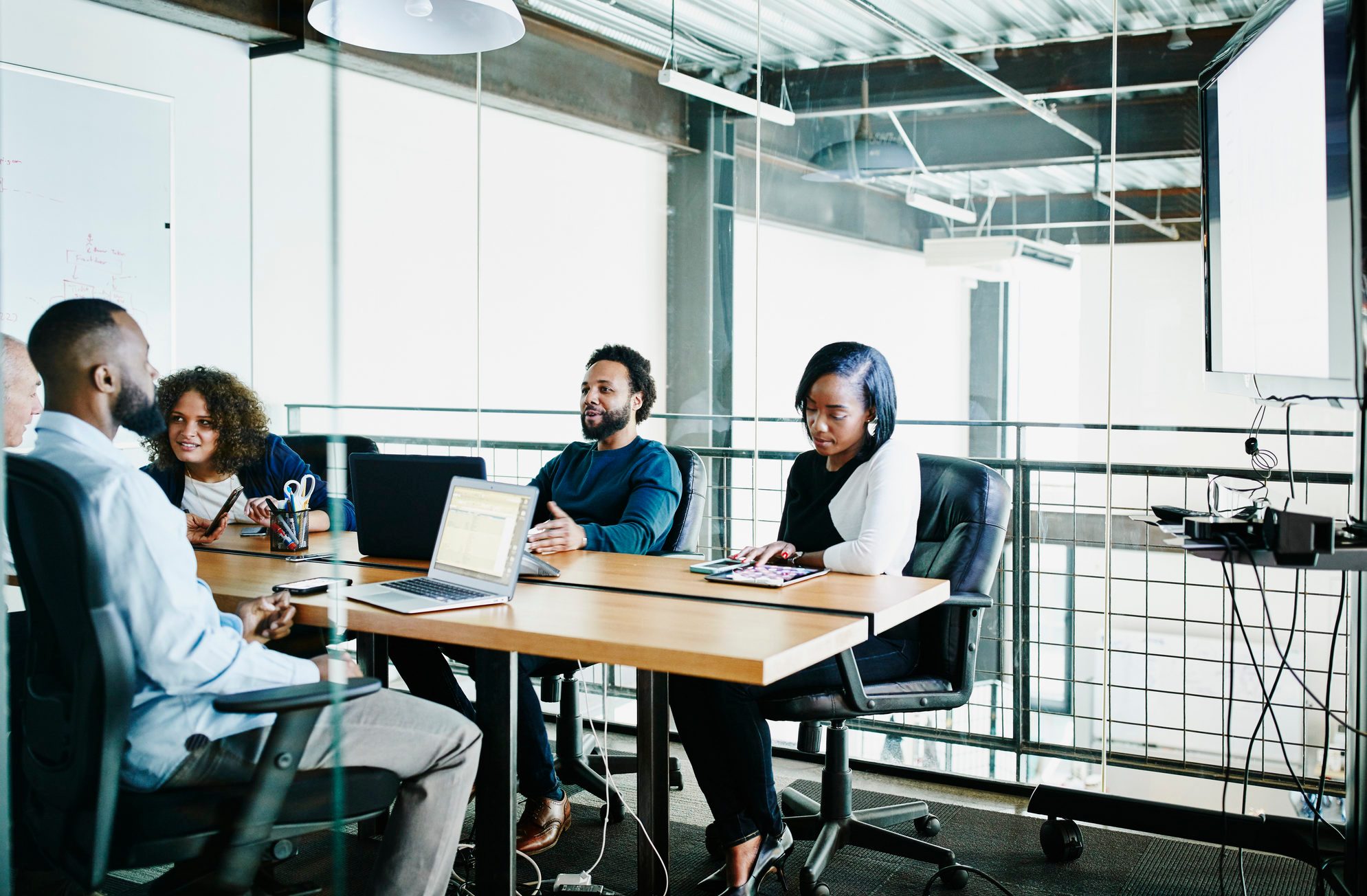 Coworkers having team meeting in office conference room