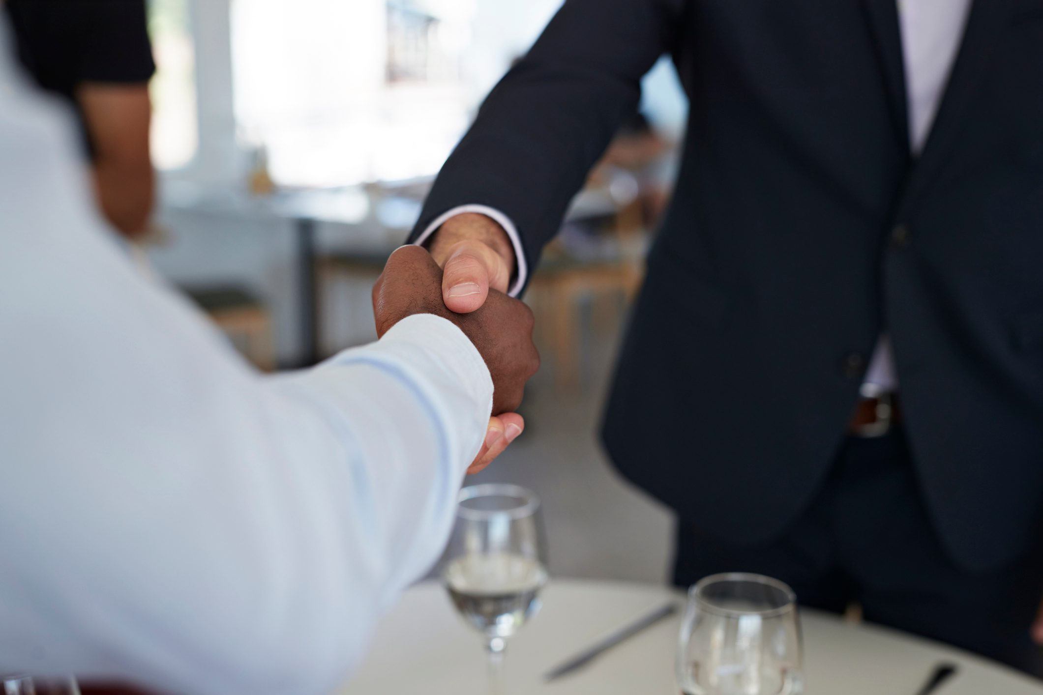 Businesspeople making handshakes, at restaurant