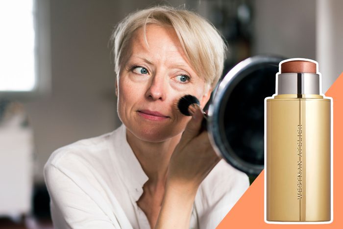 woman putting on highlighter make up