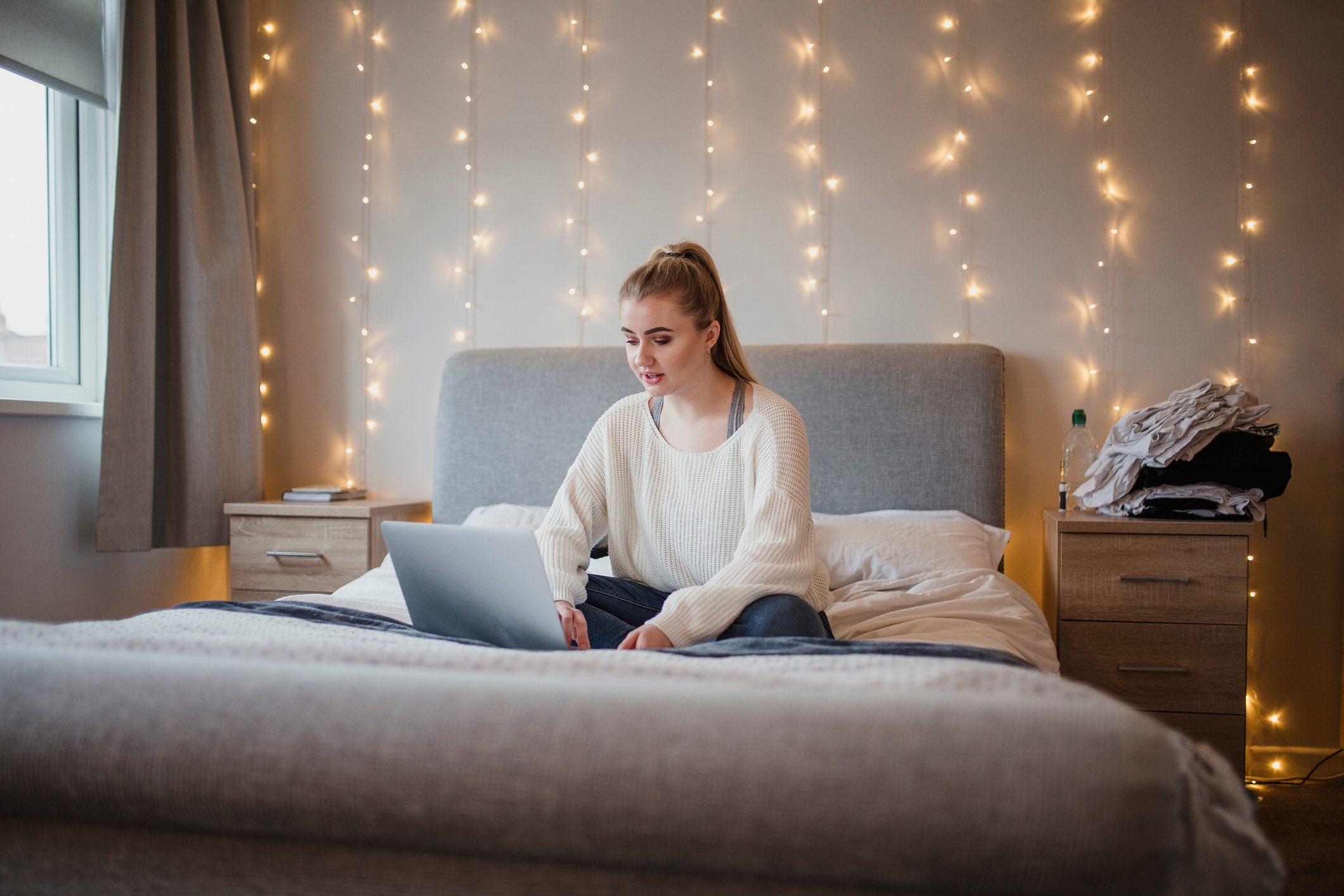 Student Using Laptop in Bedroom