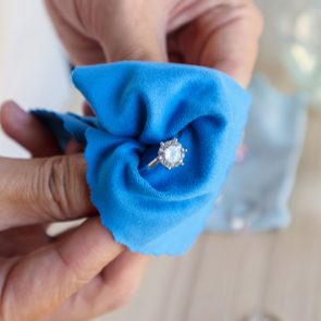 Jeweller hand polishing and cleaning jewelry diamond ring with micro fiber fabric