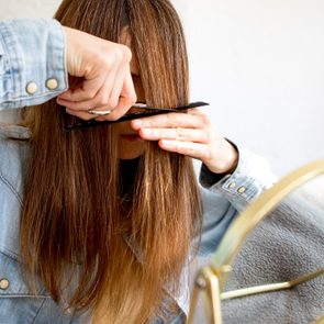 A woman cutting her own hair