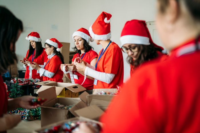 Female charity team during their work by making presents