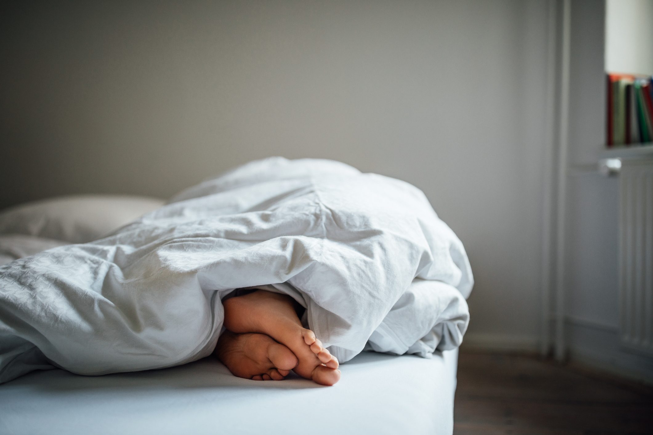 Low section of young woman sleeping in bed