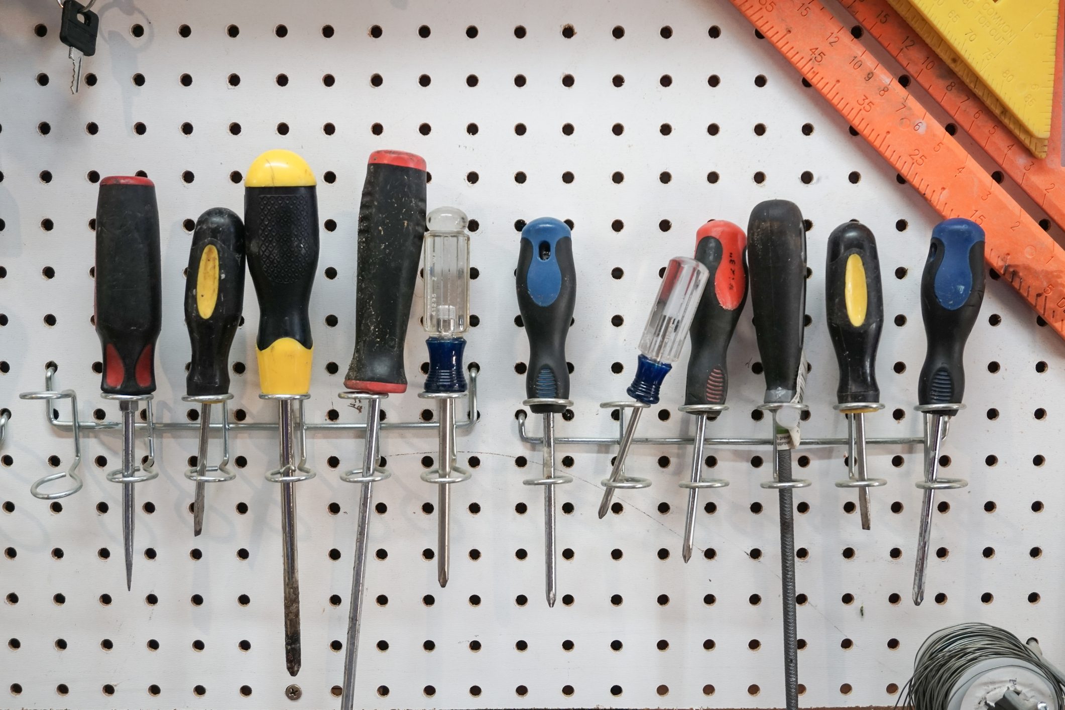 A collection of screwdrivers hanging from a pegboard