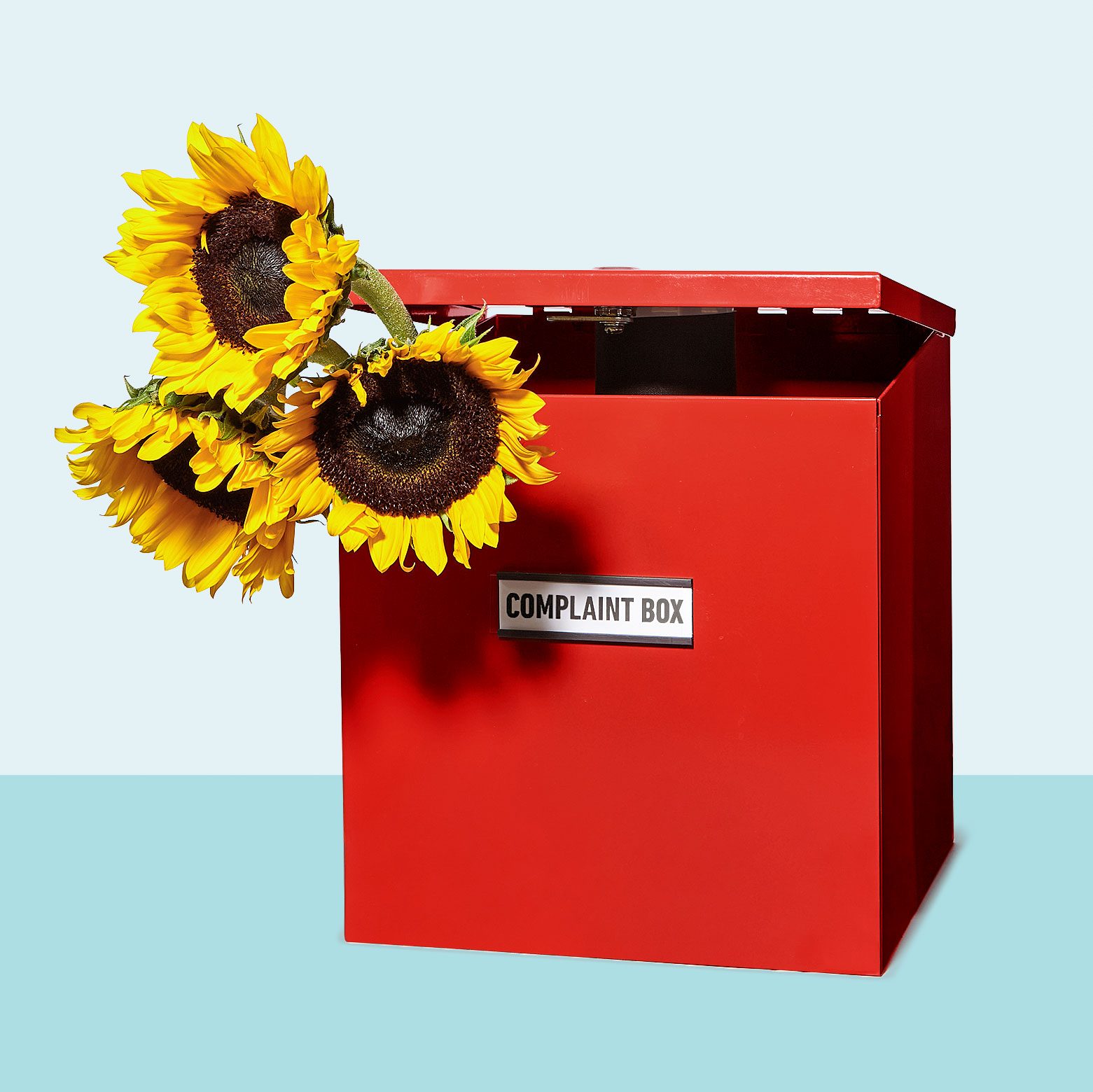 red complaint box with a bundle of sunflowers sticking out