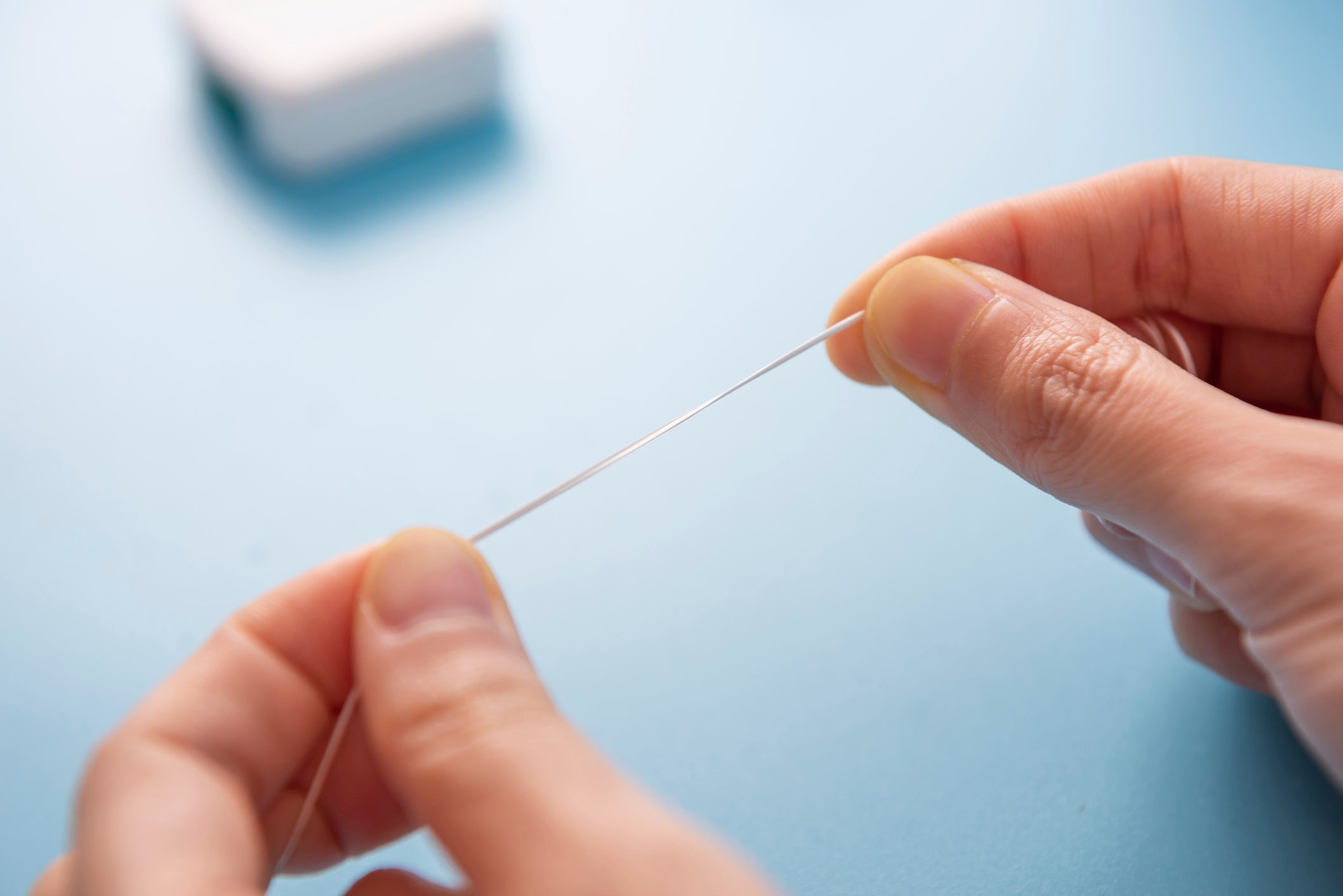 Dental health concept. Woman's hand holding dental floss,and teeth cleaning tools background