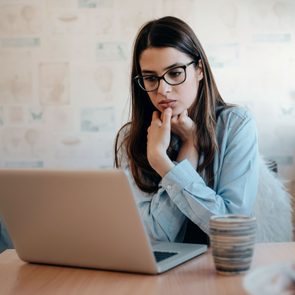 Woman looking at Apple computer, scared of suspicious scam email from Apple Support