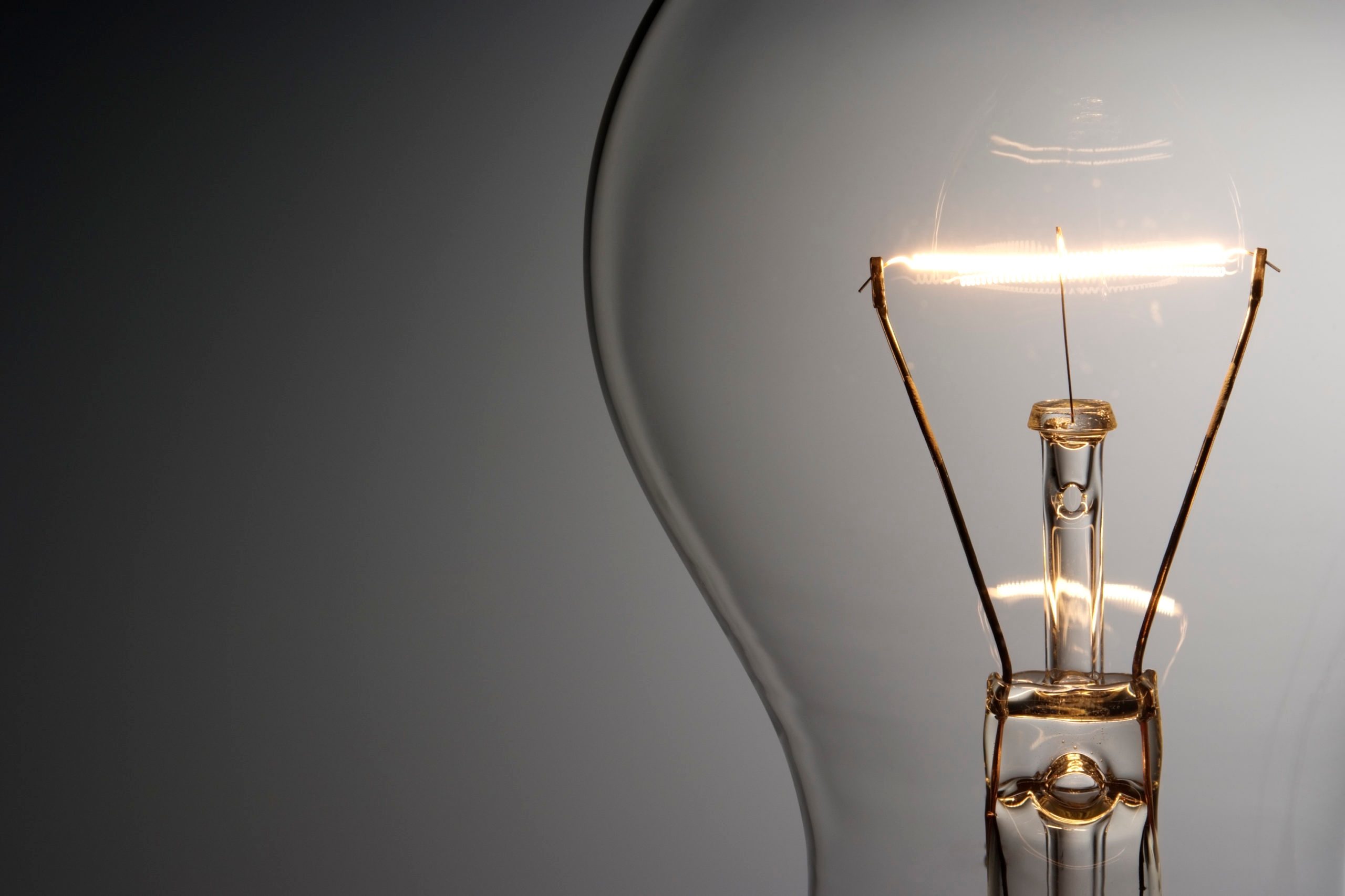 Close-up shot of illuminated light bulb with copy space