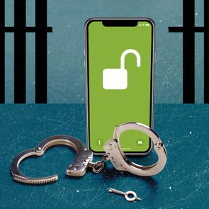 jailbroken iphone standing over unlocked handcuffs with broken jail bars in the background