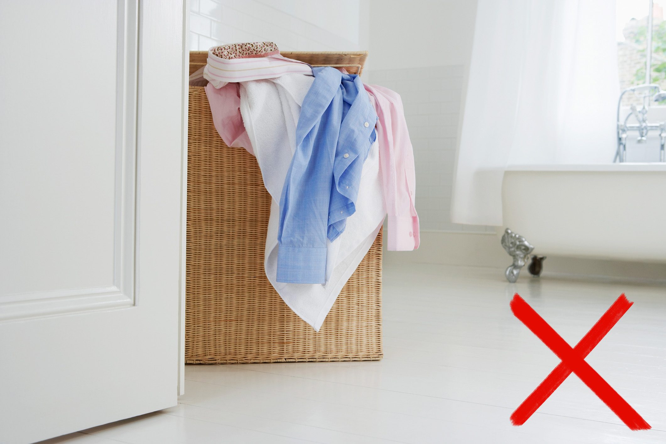 overflowing laundry basket behind bathroom door