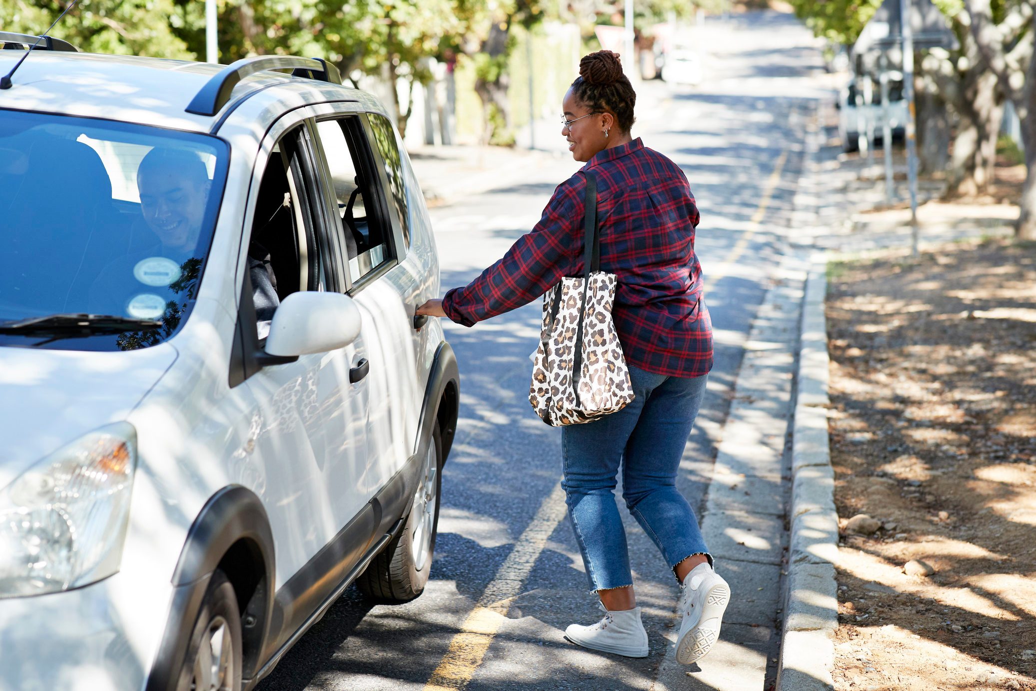 Female student opening car door on roadside