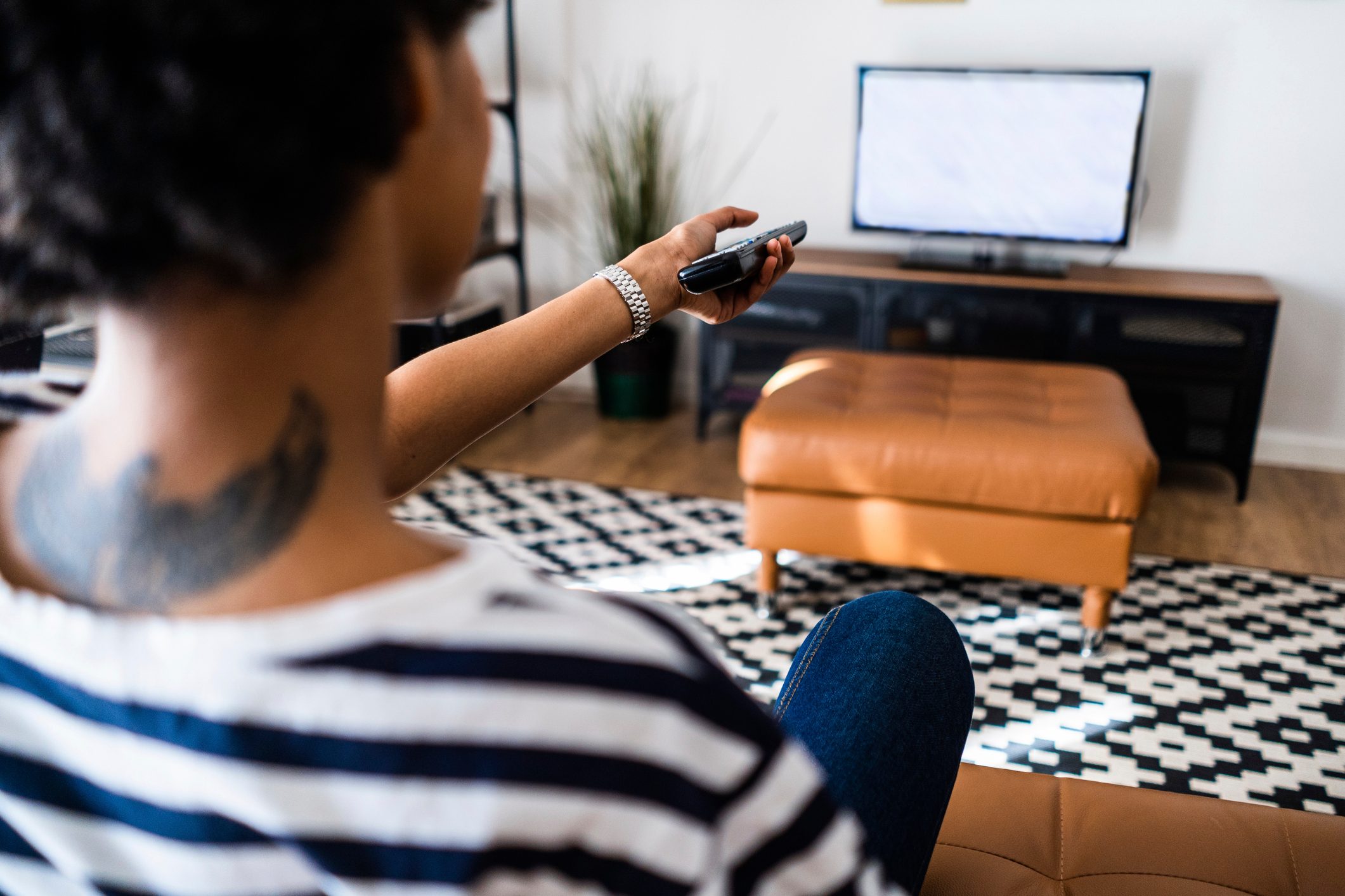 Young woman watching Tv at home