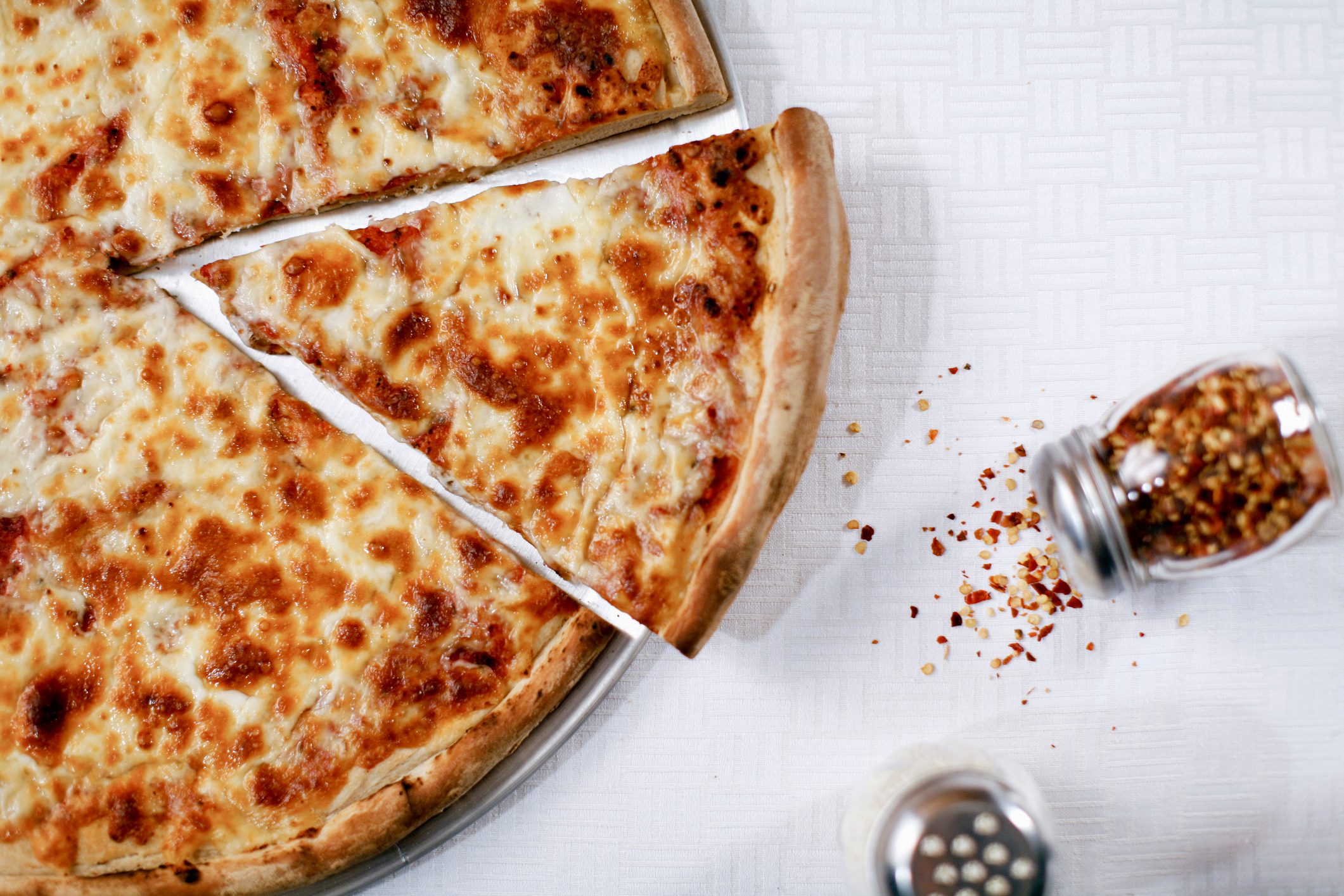 Pizza slice with spilled chili flakes