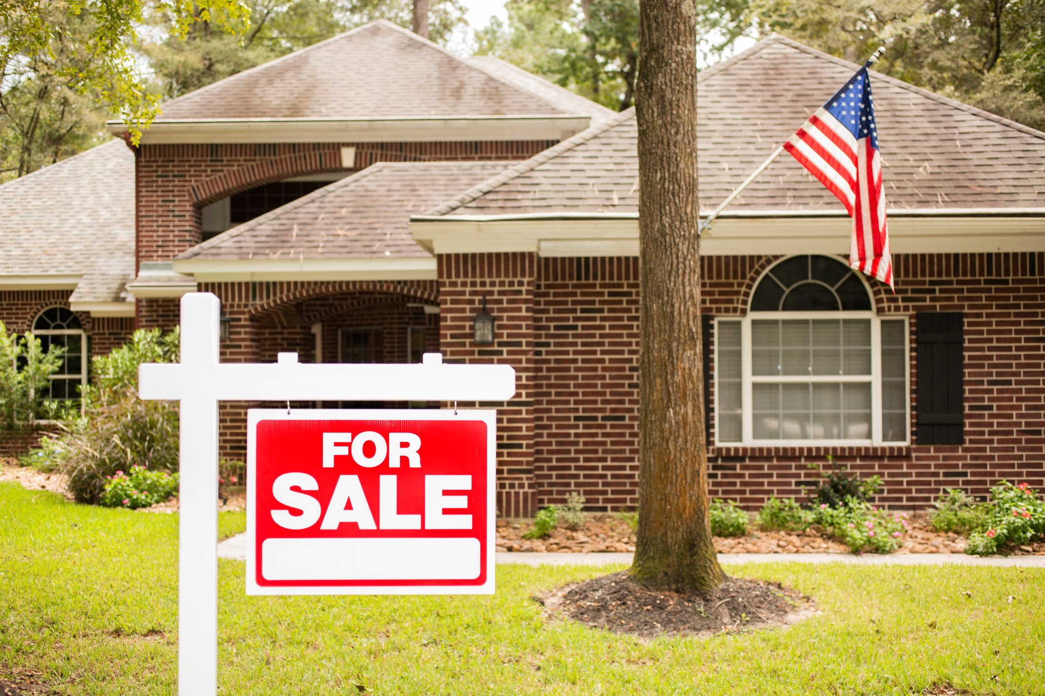 House for sale sign in front yard.