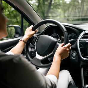 Back view of woman driving car