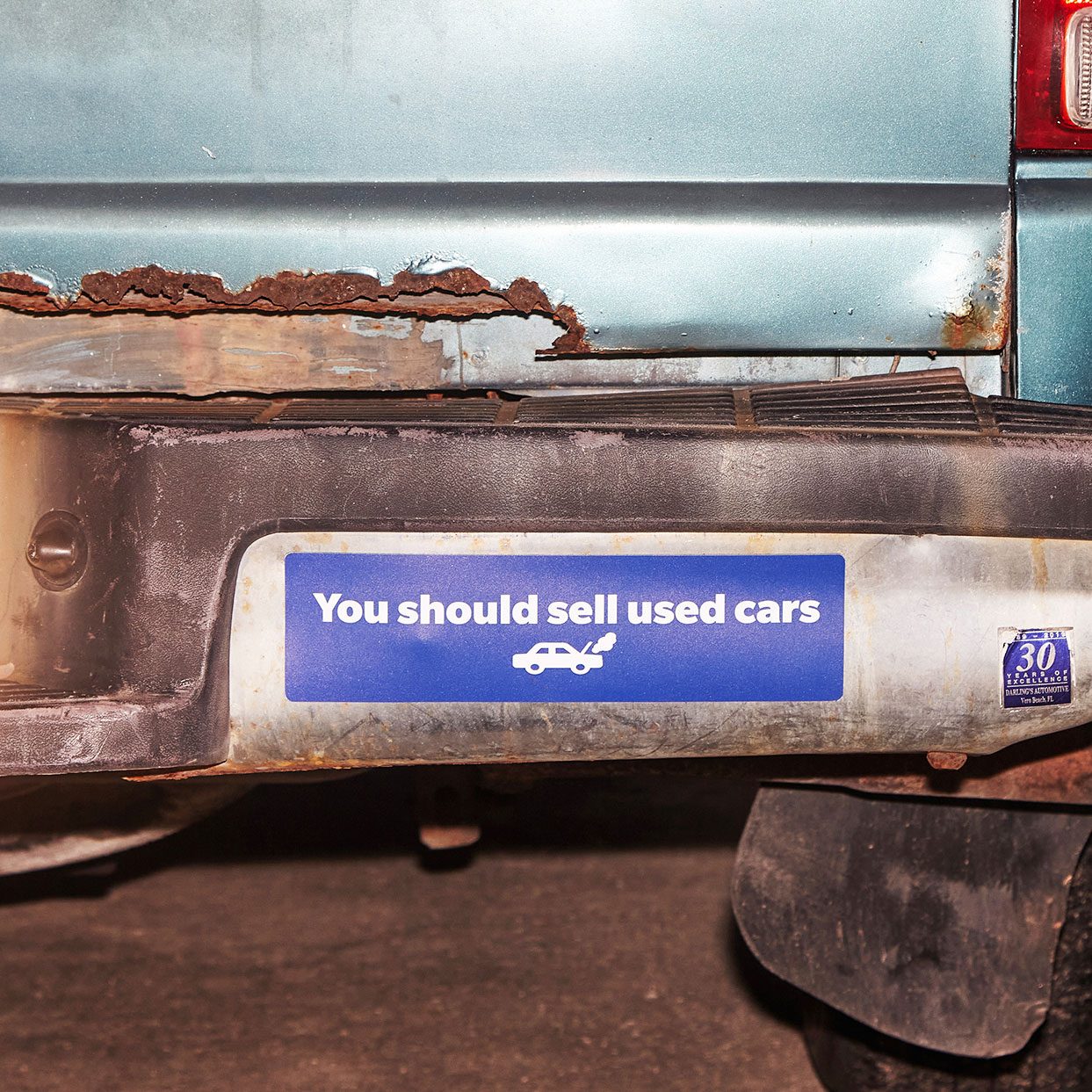 close up on a bumper sticker that reads, "You should sell used cars"