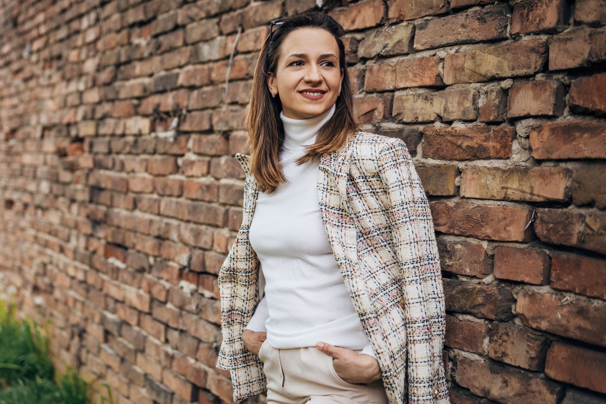 Fashionable Woman By A Brick Wall Outdoors wearing a monochromatic outfit