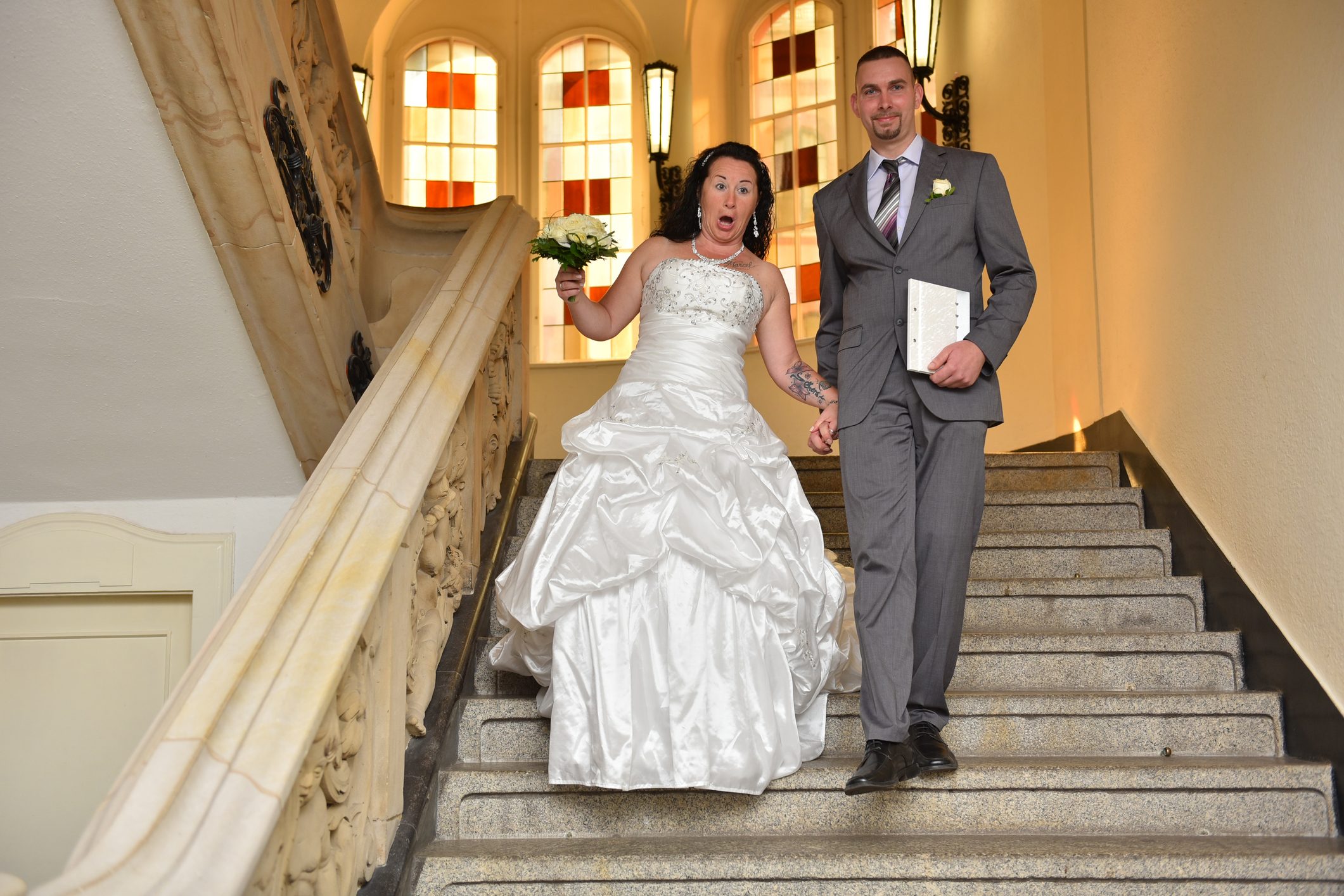 Low Angle View Of Falling Bride Holding Man On Steps