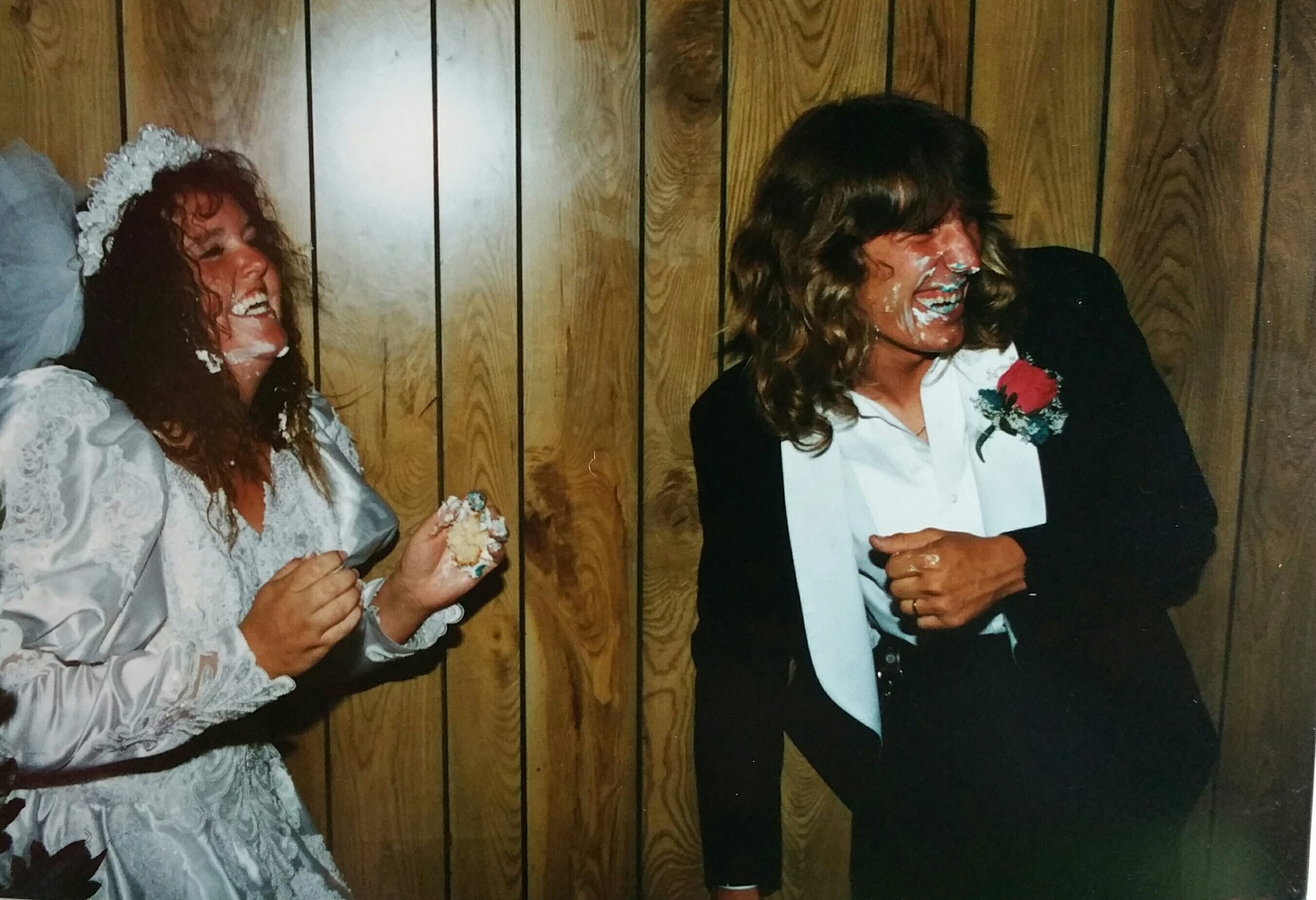 Happy Couple Playing With Cake During Wedding Reception