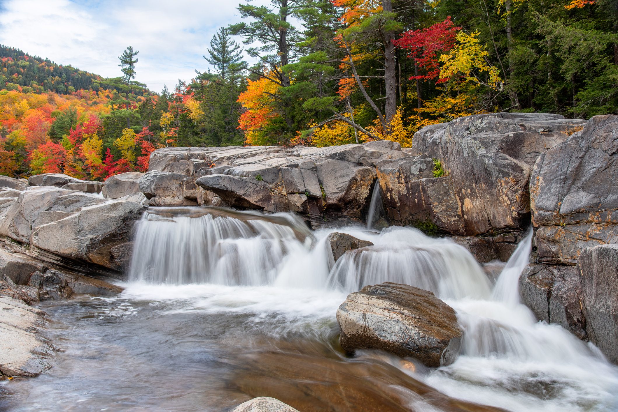 Majestic waterfall in the mountains with stunning autumn colours in background