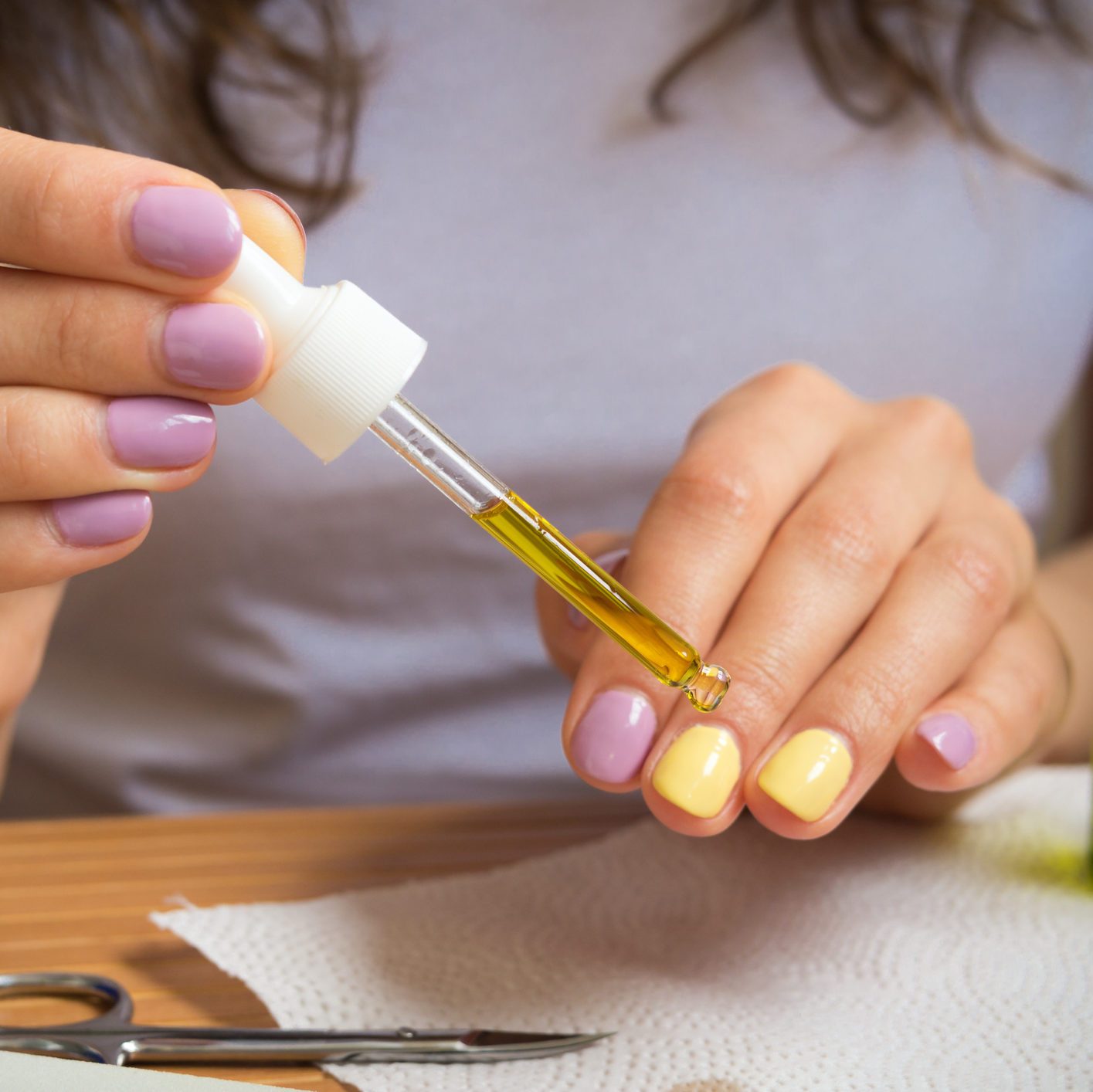 Female hand holding a pipette with oil