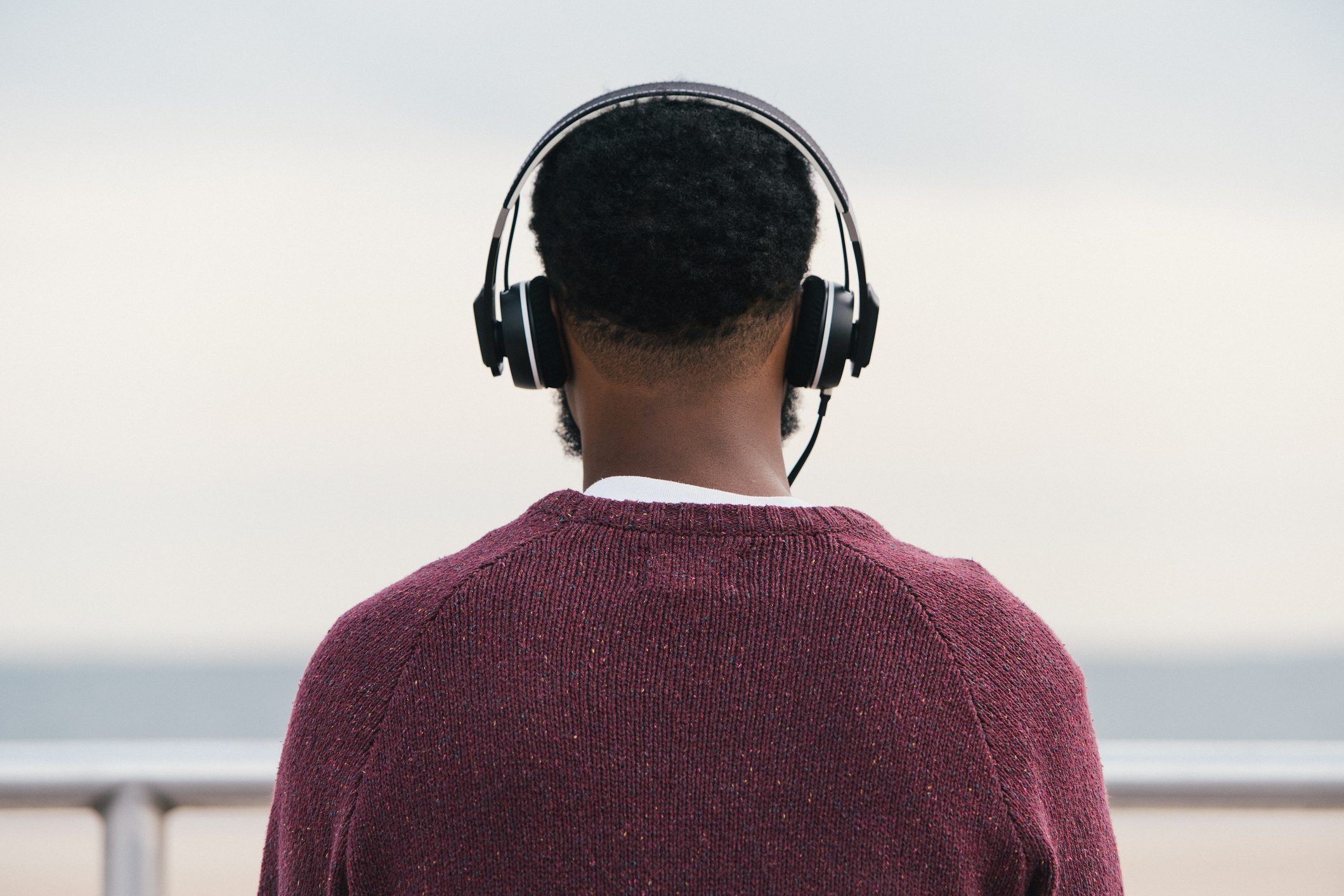 Rear view of man listening to headphones at beach, Coney Island, New York, USA