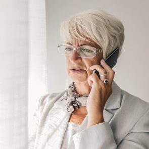 Serious senior woman talking on phone