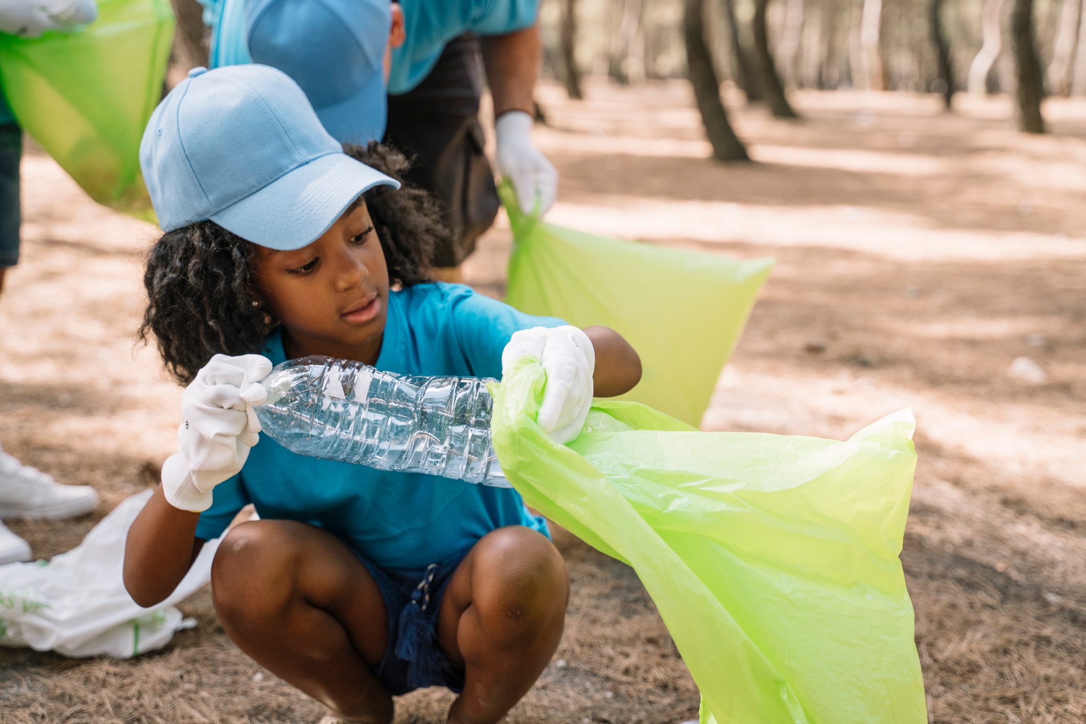 Group of volunteering children collecting garbage in a park