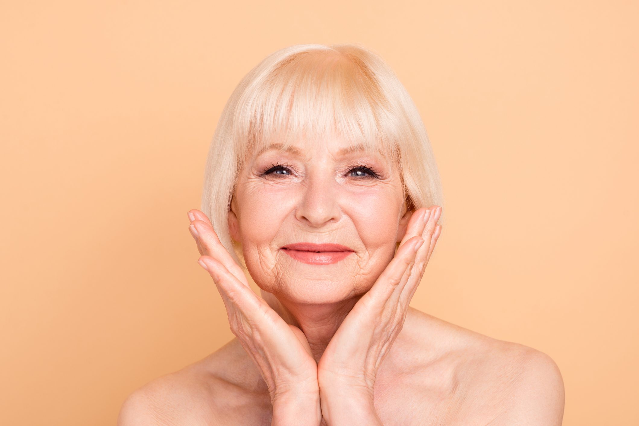 Close-up portrait of her she nice-looking attractive charming lovely sweet adorable well-groomed cheerful gray-haired lady perfect smooth clean skin isolated over beige pastel background