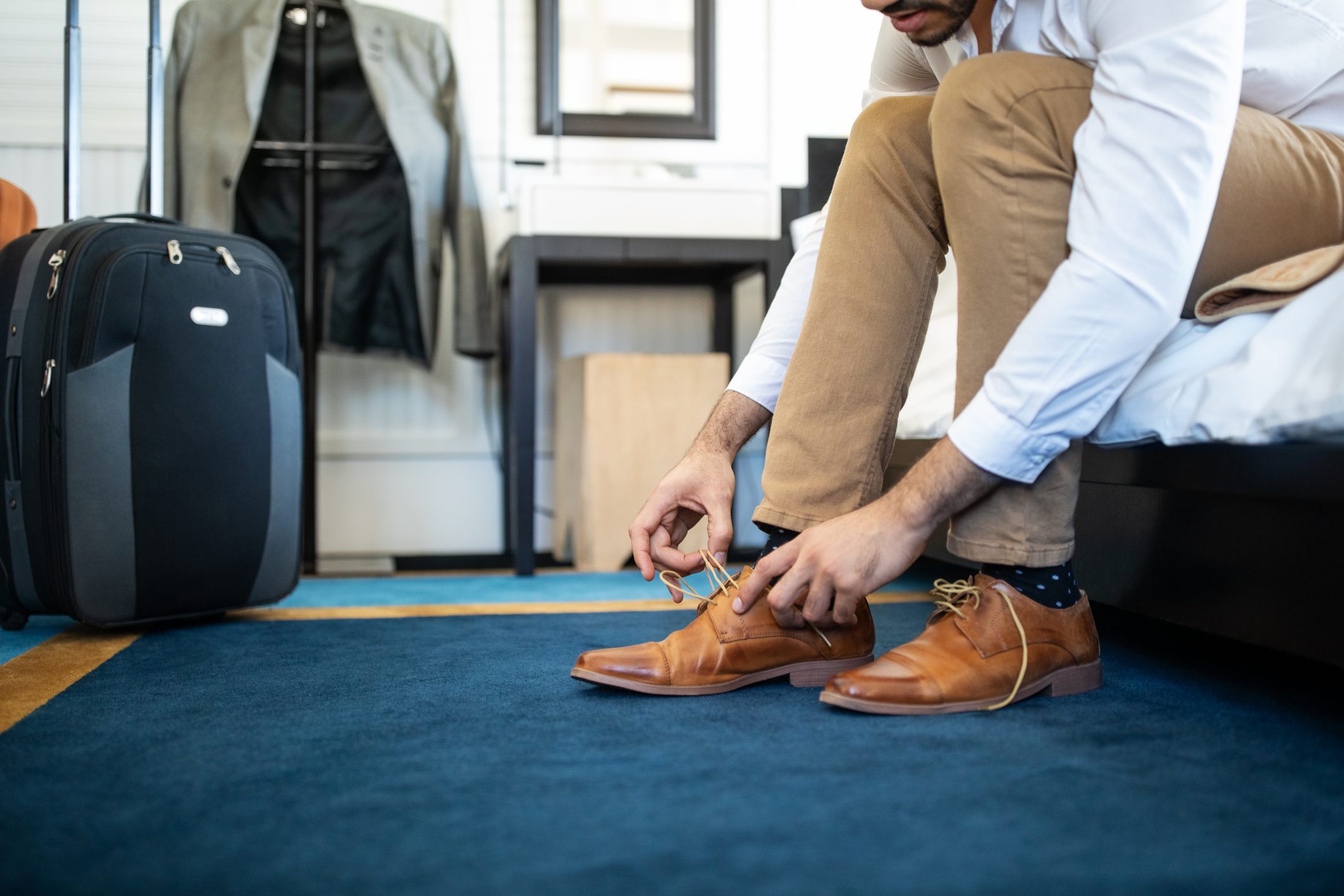 Businessman takes off his shoe in hotel room