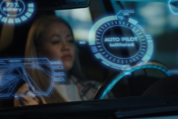 Woman engaging self driving mode in car