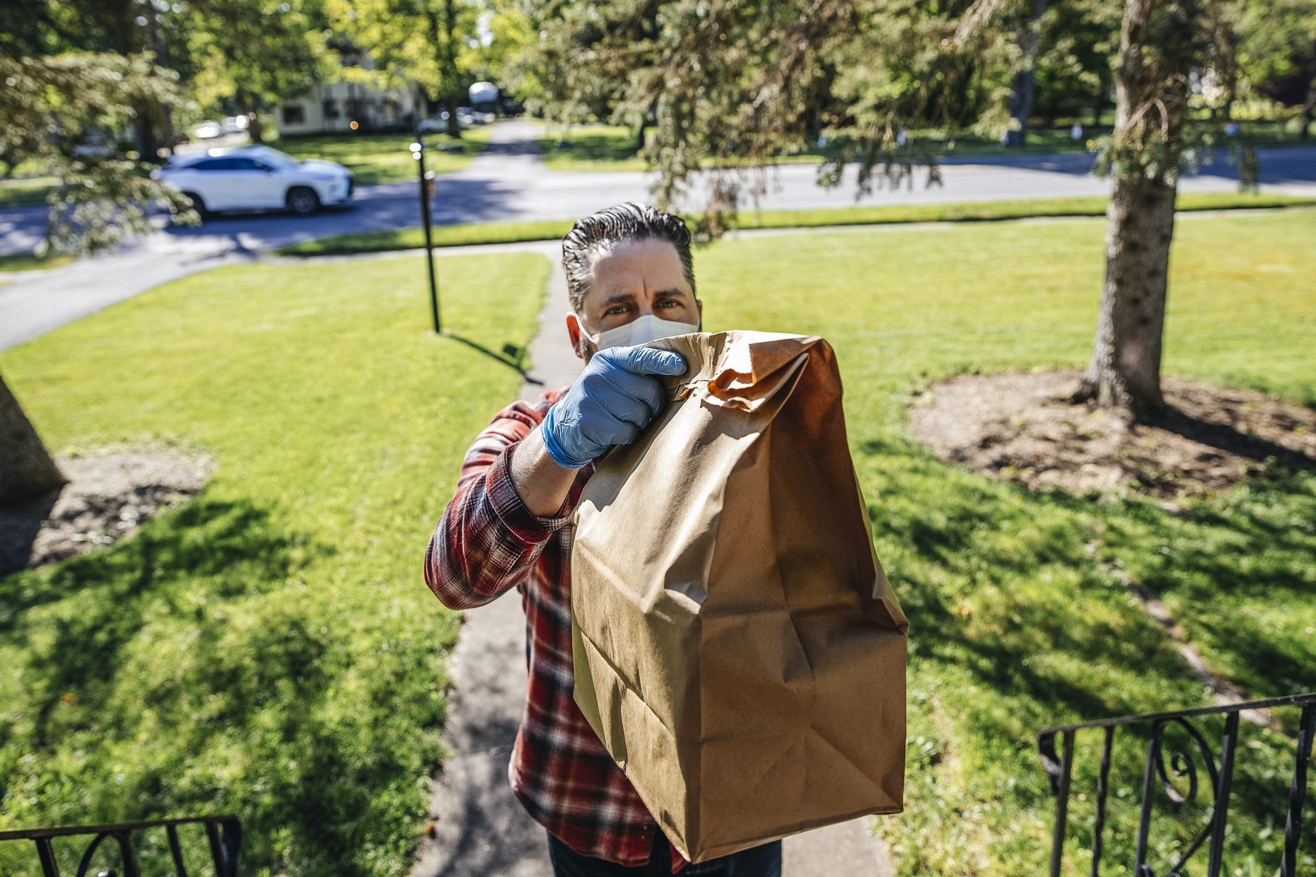 Delivery person holding bag at front door