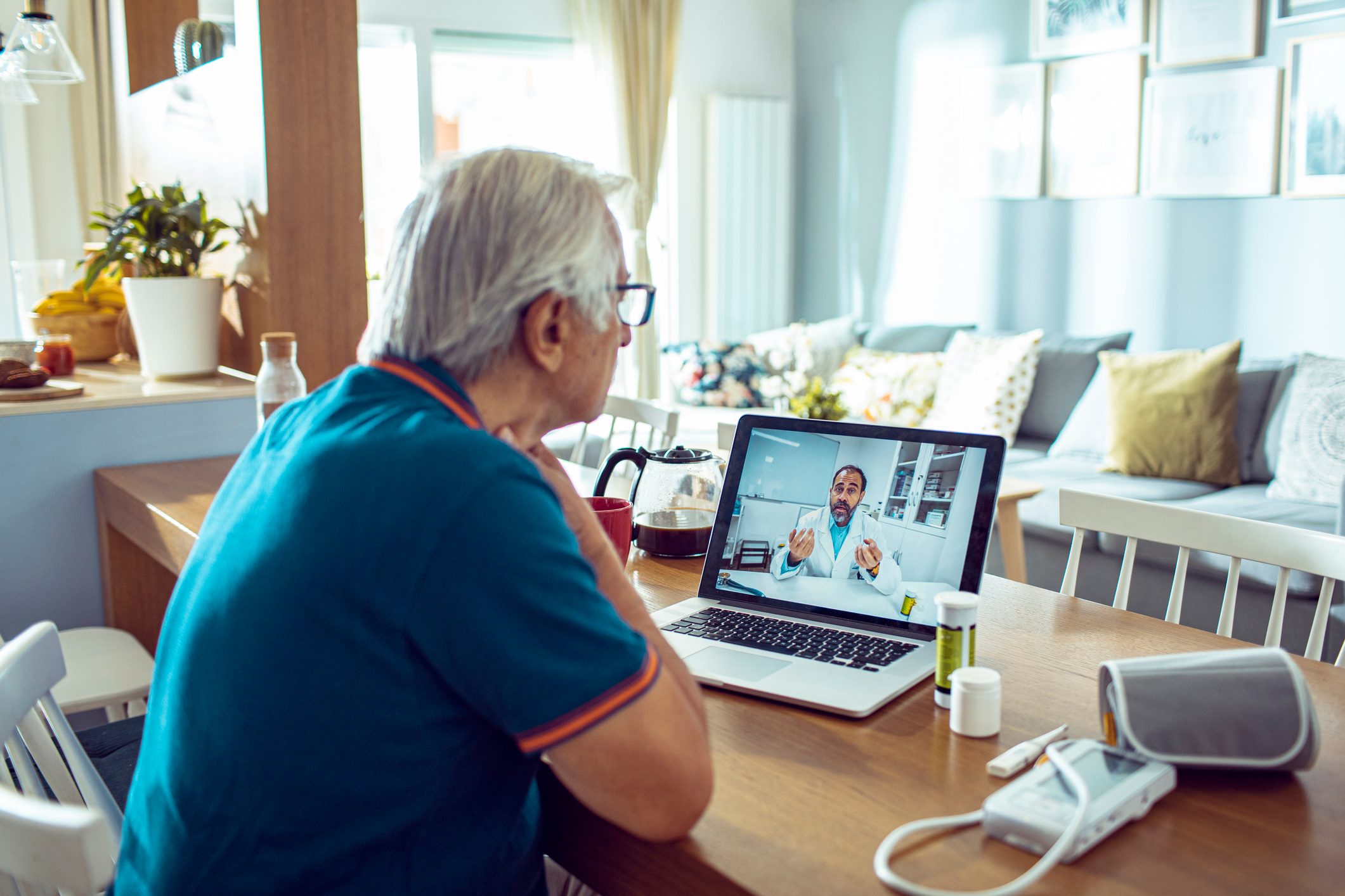 Close up of a senior man consulting with a doctor on his laptop