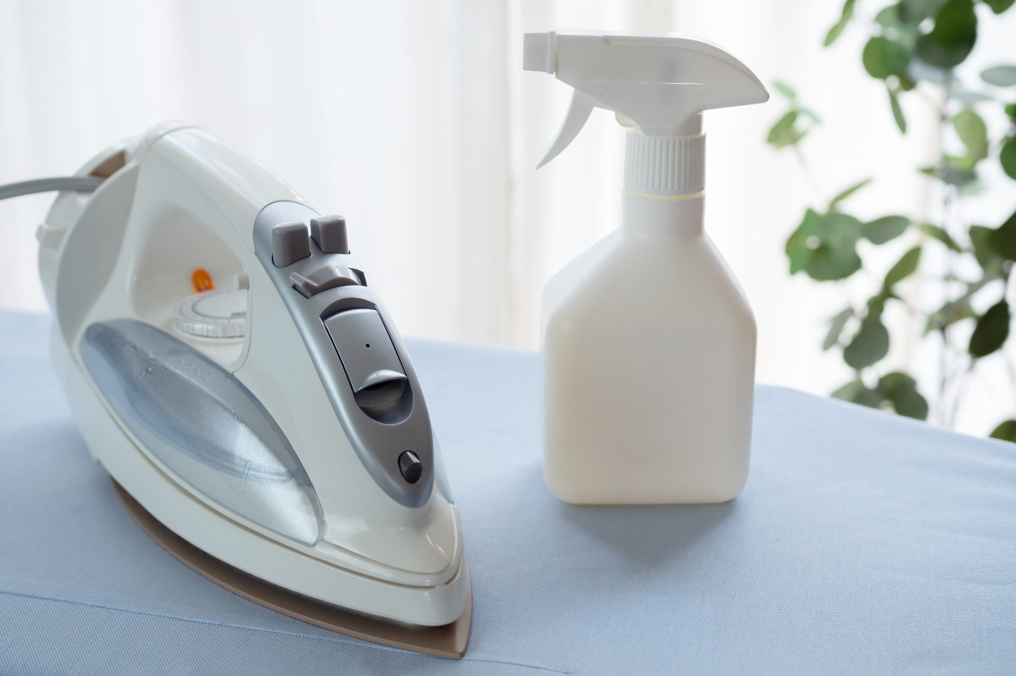 Iron and spray water bottle on ironing board